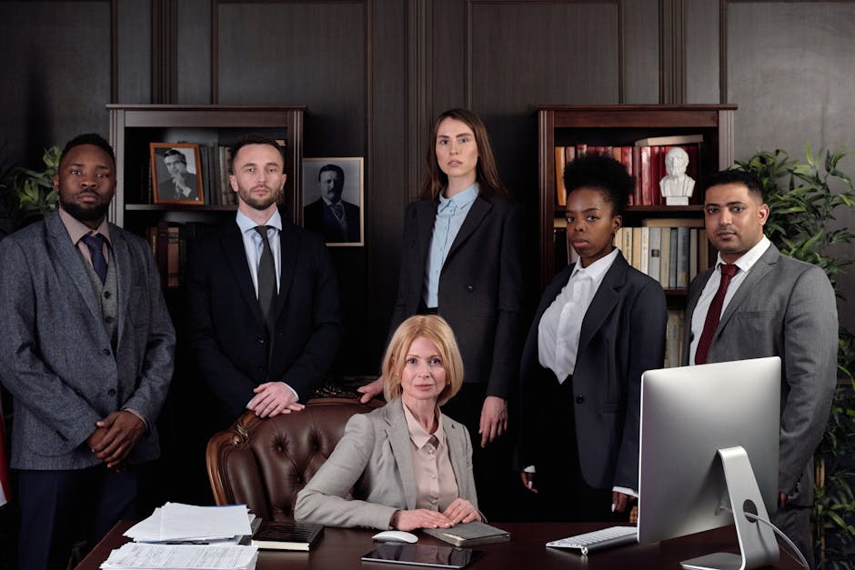 A professional looking law firm office with lawyers working on computers and discussing strategies