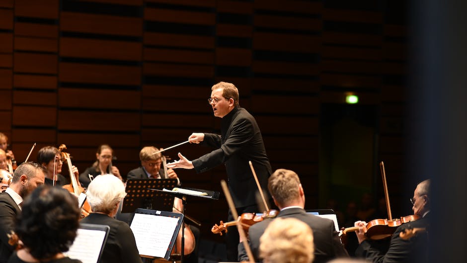 Illustration of a symphony orchestra performing on stage, with various instruments and musicians playing together to create a harmonious sound.